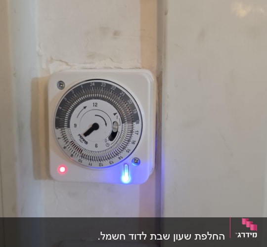 טיימר מותקן על קיר עם מתגי חשמל